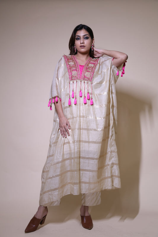 Woman wearing a traditional outfit with pink accents on a plain background Beige and pink chanderi silk kaftaan with zardozi work