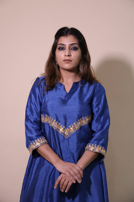 Woman wearing a blue traditional outfit with gold embroidery on a beige background Blue Silk Kurta with Exclusive Taar Dori Marodi