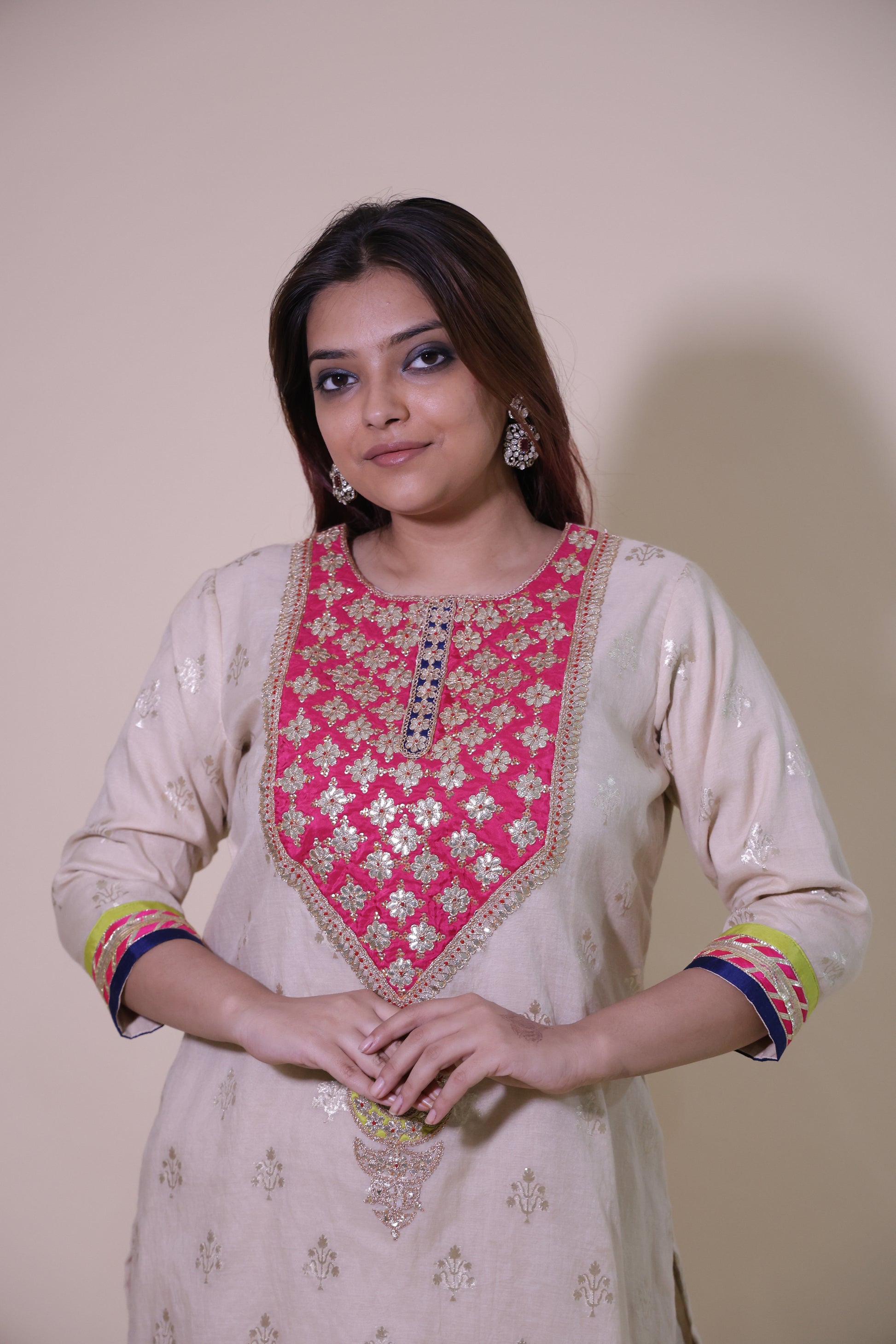 Woman wearing a traditional outfit with pink and white embroidery on a plain background Off White Chanderi Banarasi Silk Kurta Set with Patch Gottapatti