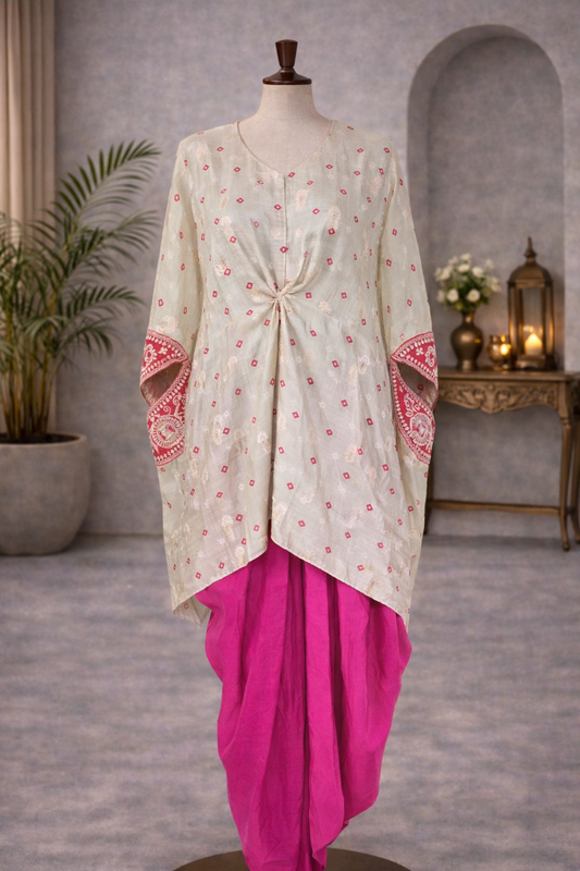 Traditional outfit with a white top and pink skirt on a mannequin against a gray wall.Pink_and_grey_bandhej_gotta_patti_kaftaan_with_dhoti