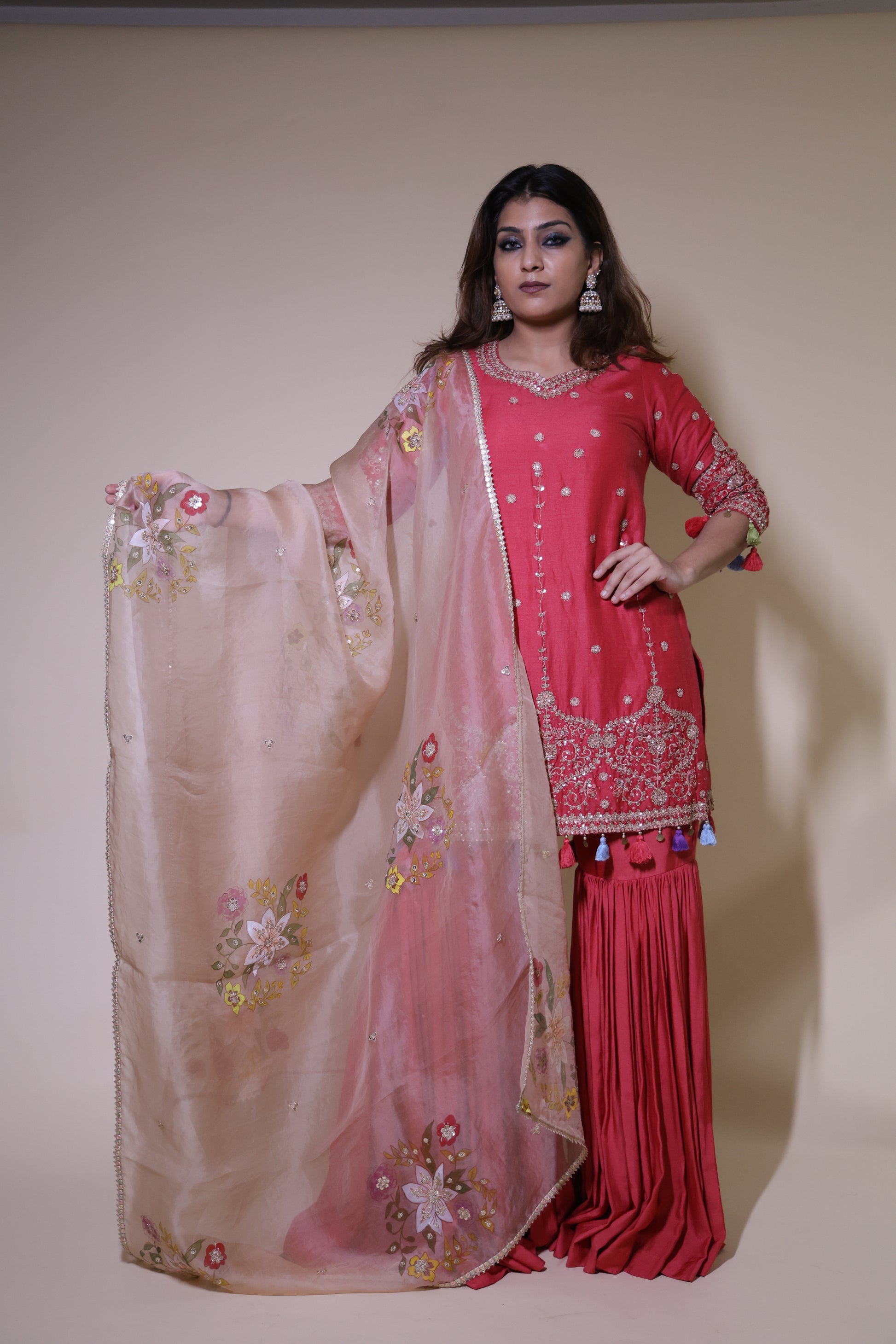 Traditional outfit with pink and red embroidered dress on a plain background Rust Orange Munga Silk Sharara Set